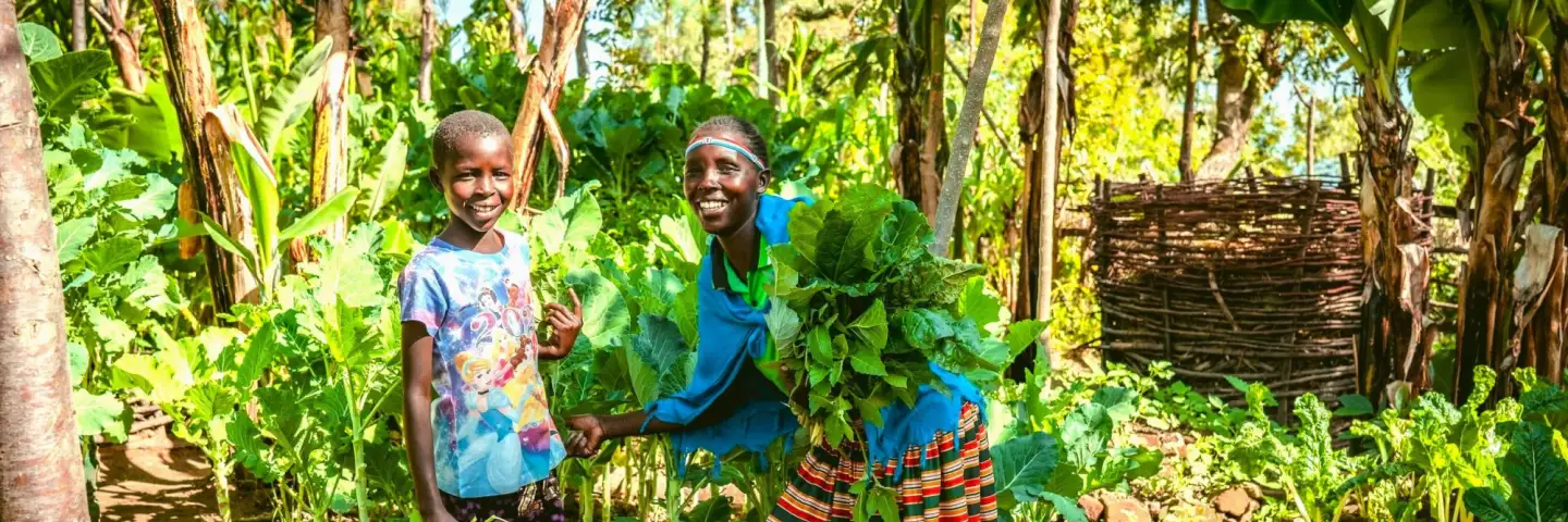 Selena and her daughter, with their healthy crops