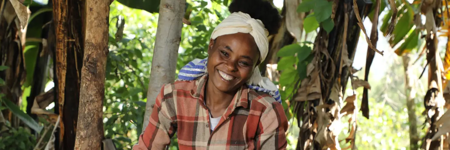Mercy, a young woman, holding her chicken and smiling
