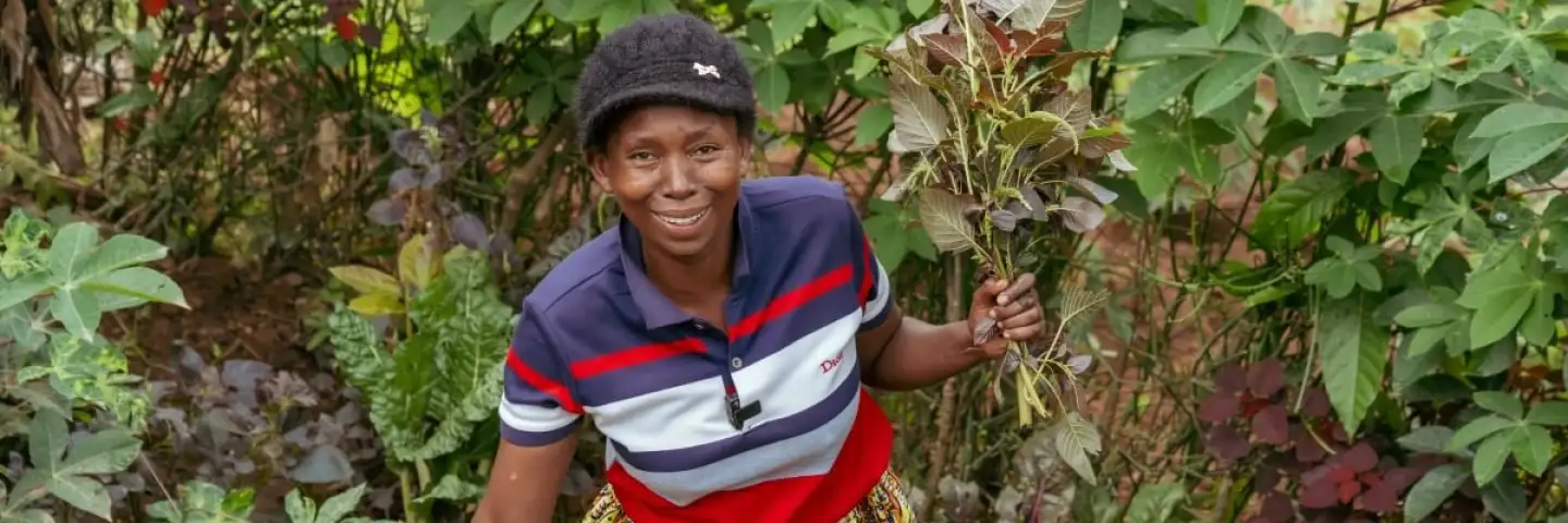 Woman farmer standing in her field with her harvest