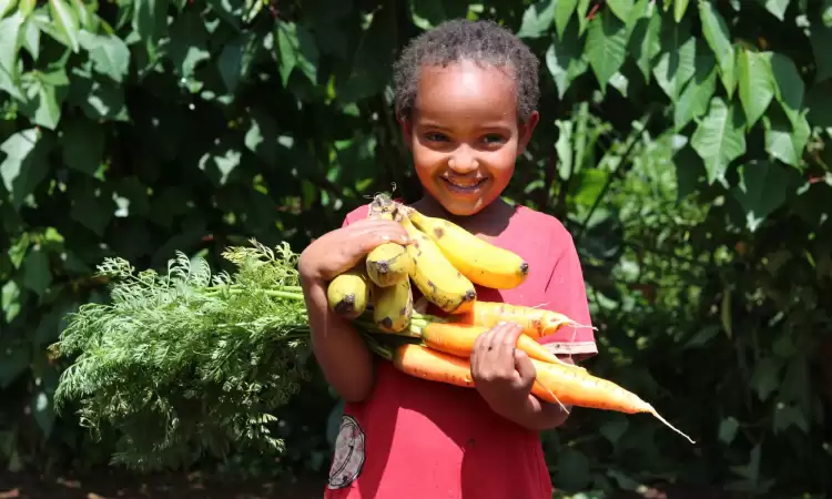 Milkiyas and Amaracholdi's daughter Diborah aged 4 holding bananas and carrots