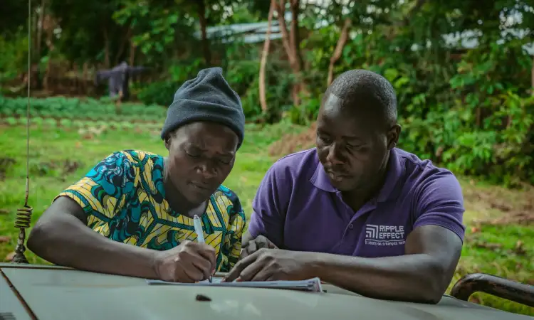 Emmanuel and Mildred sat at a table, filling a consent form together