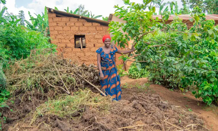 Chantal, a project participant in Rwanda, and her compost pit where she prepares organic fertilizer from manure