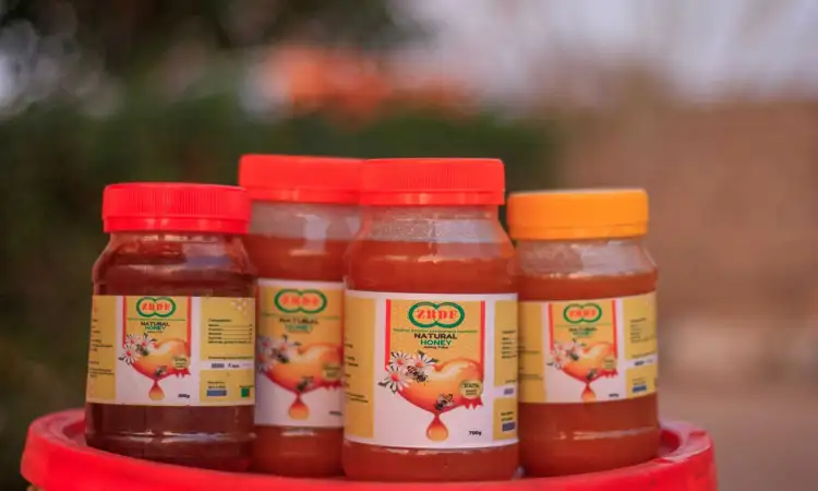 Four pots of honey with ZRDF's logo on the label