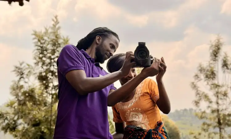Staff member showing a woman photographs on a camera outdoors.