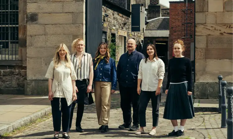 Six men and women from ilka Studio standing in business casual clothing on the street for a team shot