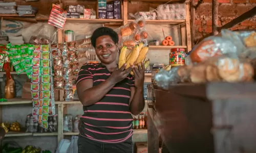 Edith in her shop holding bananas