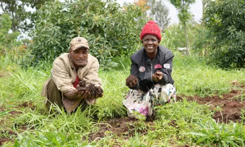 two farmers in Rwanda showing us their soil