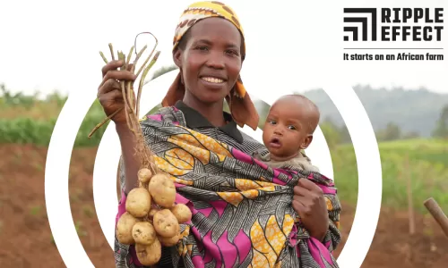 A woman holding her baby in a field