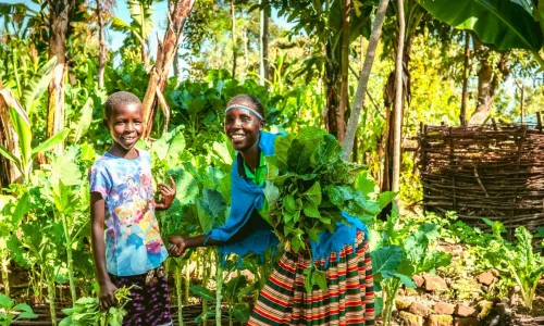 Selena and her daughter, with their healthy crops