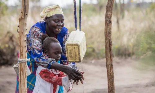 Woman showing her granddaughter how to wash her hands
