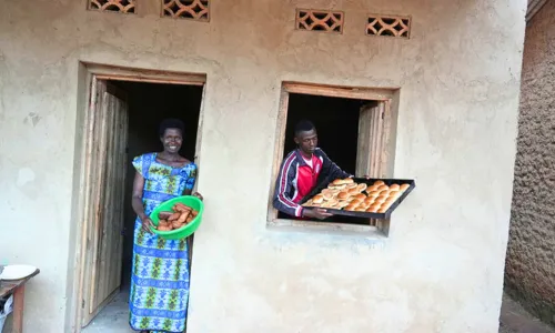 Woman and young man standing at their home with freshly baked bread from their family business
