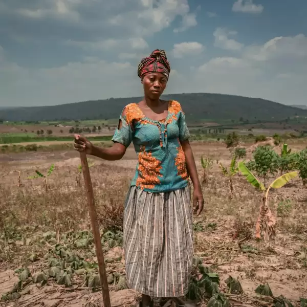 Immaculate, a Ugandan woman, standing in her dry field