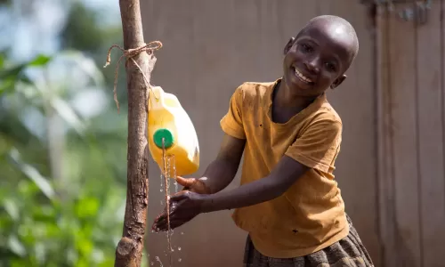 Little girl washing her hands with a tip tap