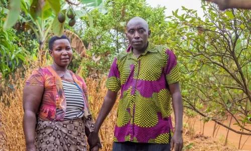 Gaspard and his wife holding hands and looking to camera