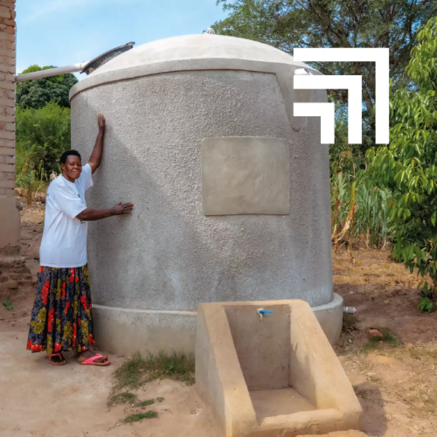 Ripple Effect farmer standing next to her rainwater harvesting tank